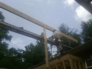 Carpenter setting a ridge beam over a new addition frame — Ice Dam Removal by Roofing Brothers in Smithville Flats