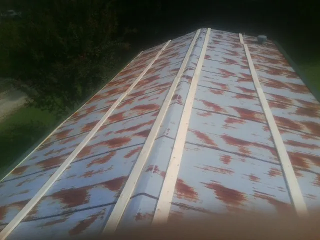 Rusted metal roof panels with new wood purlins before replacement — Storm Damage Roof Repair in Smithville Flats by Roofing Brothers