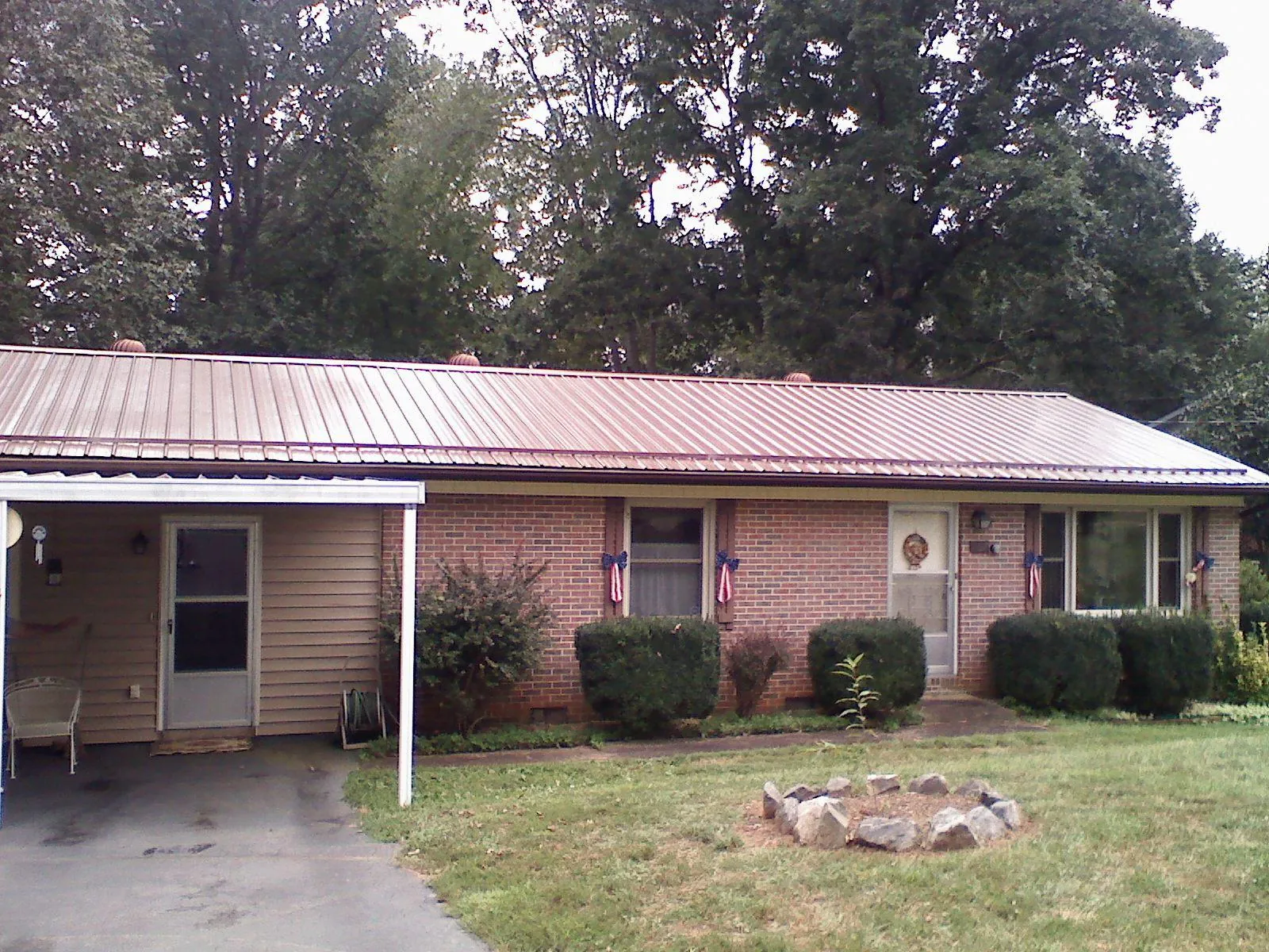 Bronze metal roof and carport on a brick ranch home — Roof Repair work by our crew in Smithville Flats